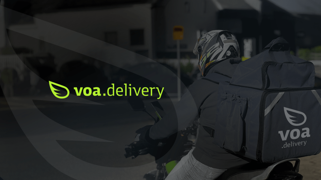 Equipe de cozinha de delivery observa gráfico projetado na parede mostrando crescimento de pedidos e redução de custos